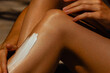 © Mirrorstudio - Close-up of caucasian female applying moisturizing lotion on legs outdoors. Skin care, sun protection