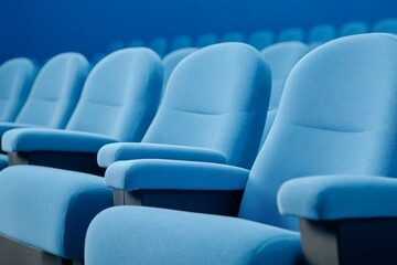 Poster - Silhouette of Empty Blue Cinema Interior with Rows of Unoccupied Seats and a Soft Blue Light, Capturing the Essence of Abandonment and Tranquility in a Movie Theater Setting