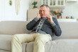 © Юлия Завалишина - Headache pain. Unhappy middle aged senior man suffering from headache sick rubbing temples at home. Mature old senior grandfather touching temples experiencing stress. Man feeling pain hurt in head