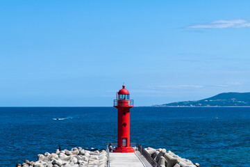 Wall Mural - red lighthouse on the seawall at the harbor