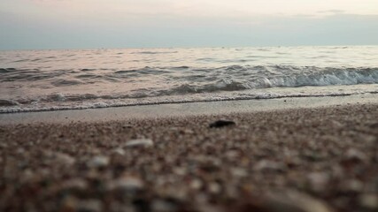 Poster - Soft waves roll onto a sandy beach as twilight sets in. The calm sea reflects the fading light, creating a serene atmosphere for evening relaxation. Reflection of pink rays. Mediterranean Adriatic Sea