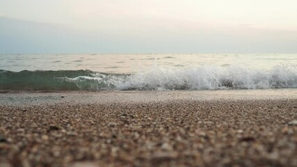 Poster - Soft waves roll onto a sandy beach as twilight sets in. The calm sea reflects the fading light, creating a serene atmosphere for evening relaxation. Reflection of pink rays. Mediterranean Adriatic Sea