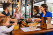 © Mediteraneo - Family and friends gathered in a restaurant to eat delicious food, talk, drink and hang out.
