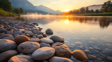 Poster - A serene view of smooth river stones at the water's edge, with mist rising from the calm water at sunrise, symbolizing peace, nature, and the beauty of the morning light.