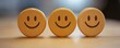 © HISTOCK - Three wooden disks showing happy smiley faces expressing customer satisfaction