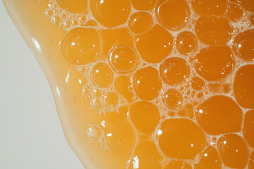 Poster - Bubbles of Amber Delight: An abstract capture of light dancing on the surface of amber-colored liquid. The image features a vibrant display of bubbles.