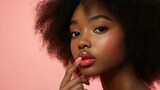 Model with lips with lip balm looking natural and juicy, light pink background.