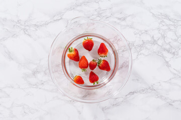 Wall Mural - Preparing Strawberries in a Glass Mixing Bowl with Water