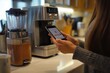 © mirifadapt - woman standing at a sleek kitchen counter, holding her smartphone, making an online payment