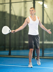 Wall Mural - Active man with enthusiasm playing padel on the tennis court