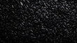 © Artem - Abundant black sesame seeds falling against a dark background for culinary and design purposes