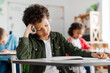 © Home-stock - Upset tired Latin boy student of elementary school trying to solve mathematical problems or writing test in classroom