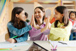 © Home-stock - Happy female teacher giving high five to school girls and smiling to each other, celebrating result of tests and enjoying time after lesson at school