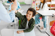 © Home-stock - Happy Latin boy giving high five to teacher, celebrating good mark for exam. Achievement, success and mentorship for learning