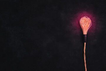 Wall Mural - A light bulb is lit up and is surrounded by a black background