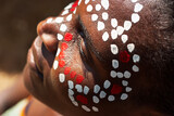 Tribal portrait single african woman with braids dreadlocks outdoors, painted face with white and red dots