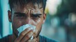 © BlackBird Studio - Close-Up of Sweaty Young Man Wiping Face with Tissue in Outdoor Setting