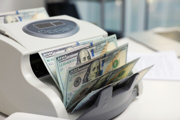 Wall Mural - Modern banknote counter with money on white table indoors, closeup