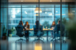© The Yudel Media - A professional office meeting room with a blurred view of business professionals engaged in discussion, framed by glass walls and natural light.