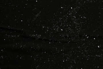 Wall Mural - a black background with scattered white specks and scratches, resembling dust or film grain