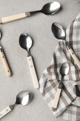 Wall Mural - Different silver spoons and napkin on grey background