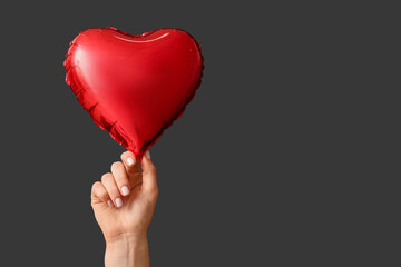 Canvas Print - Woman with air balloon in shape of heart on black background. Valentine's Day celebration