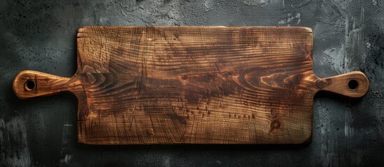Aufkleber - Wooden rectangular cutting board with handles positioned horizontally on dark concrete background, rich brown color emphasizes texture and depth.