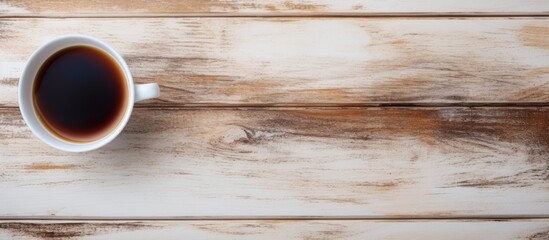 Poster - Flat lay of a cup of black coffee on a white wooden table with a rustic texture and ample copy space on the right for text insertion