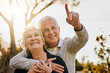 © Beak Joint/peopleimages.com - Hug, pointing and senior couple in park for wellness, bonding and fresh air on weekend. Retirement, marriage and happy elderly man and woman with view in nature, outdoors and garden in morning