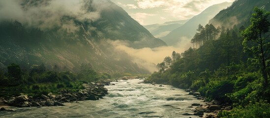 Aufkleber - Serene river winding through a misty mountainous landscape with lush green trees on the left, soft gray clouds above, ideal for copy space.