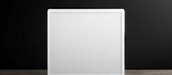 Poster - Modern tablet PC showcasing a blank white screen placed on a wooden table against a matte black background with ample copy space for customization.