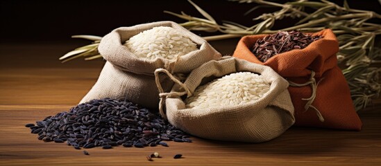 Poster - Jasmine rice and Riceberry rice in beige and orange hemp sacks with black rice on wooden surface natural lighting and rustic ambiance