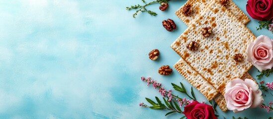 Poster - Delicate arrangement of crispy matzah on a soft blue background framed by pink roses and green herbs with walnuts scattered elegantly