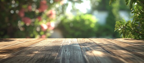 Fototapete - Wooden table top texture in foreground with blurred green garden leaves and sunlight background creating a warm inviting display space.