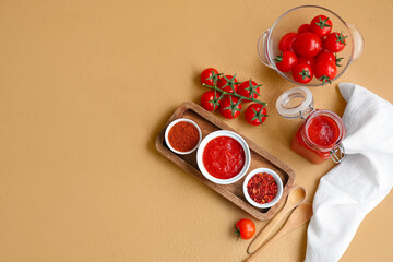 Wall Mural - Bowl and jar of tomato sauce with spices on brown background