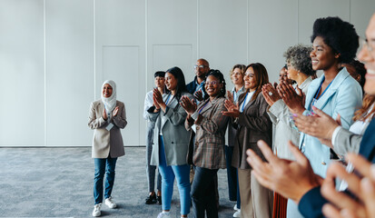 Wall Mural - diverse conference crowd clapping and smiling in a meeting room