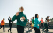 © Jacob Lund - Smiling muslim female runner waving during marathon event