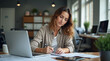 © igor.nazlo - Woman at workplace listning training video course webinar, office worker writing training data in notebook, businesswoman serious and focused inside office at workplace