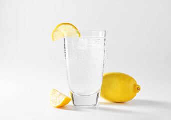 Canvas Print - Refreshing soda water in glass and lemon on light grey background