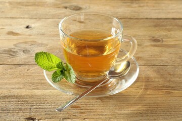 Wall Mural - Freshly brewed tea in glass cup on wooden table