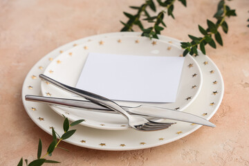 Wall Mural - Stylish table setting with plates, cutlery, blank paper card and plant branches on beige grunge background