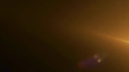 Poster - Golden light leak gradually spreading across dark background, creating warm visual transition with soft optical glimmer for video editing and motion graphic design