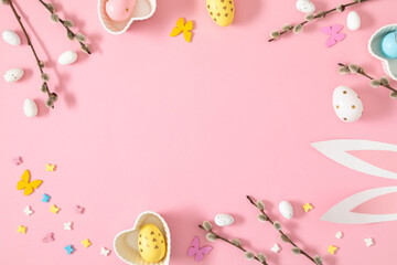 Wall Mural - easter festive frame on pink background. decorative easter eggs bunny ears, a branch of a flowering 