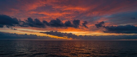 Aufkleber - Vibrant Sunset Over the Ocean with Dramatic Red Orange and Blue Sky Colors Illuminating Clouds Reflected on Water
