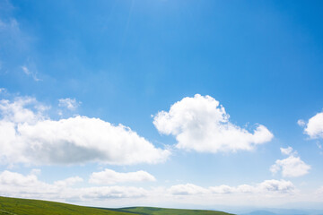 Wall Mural - white cumulus clouds on a blue sky. horizon above mountain. wonderful nature background of atmospher