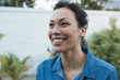 © Wavebreak Media - Wearing denim shirt, woman outdoors under sun with joyful expression