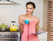 © Wavebreak Media - Smiling woman in kitchen holding coffee mug and tablet, enjoying morning