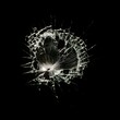 © Pablo - Broken glass with central impact and radial cracks on a black background, highlighting details of the fractured crystal. Shattered glass texture with light effects on the cracks