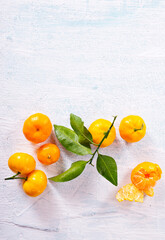 Sticker - Orange fruit with green leaves on the white wood.