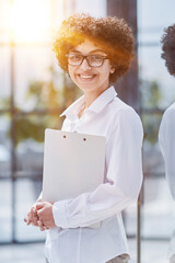 Wall Mural - Smiling confident business leader looking at camera and standing in an office